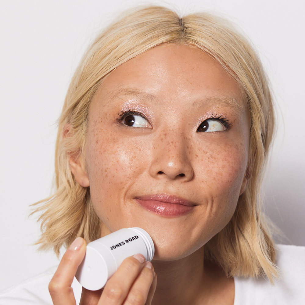 A woman applying Jones Road Beauty's Cleansing Stick to her chin