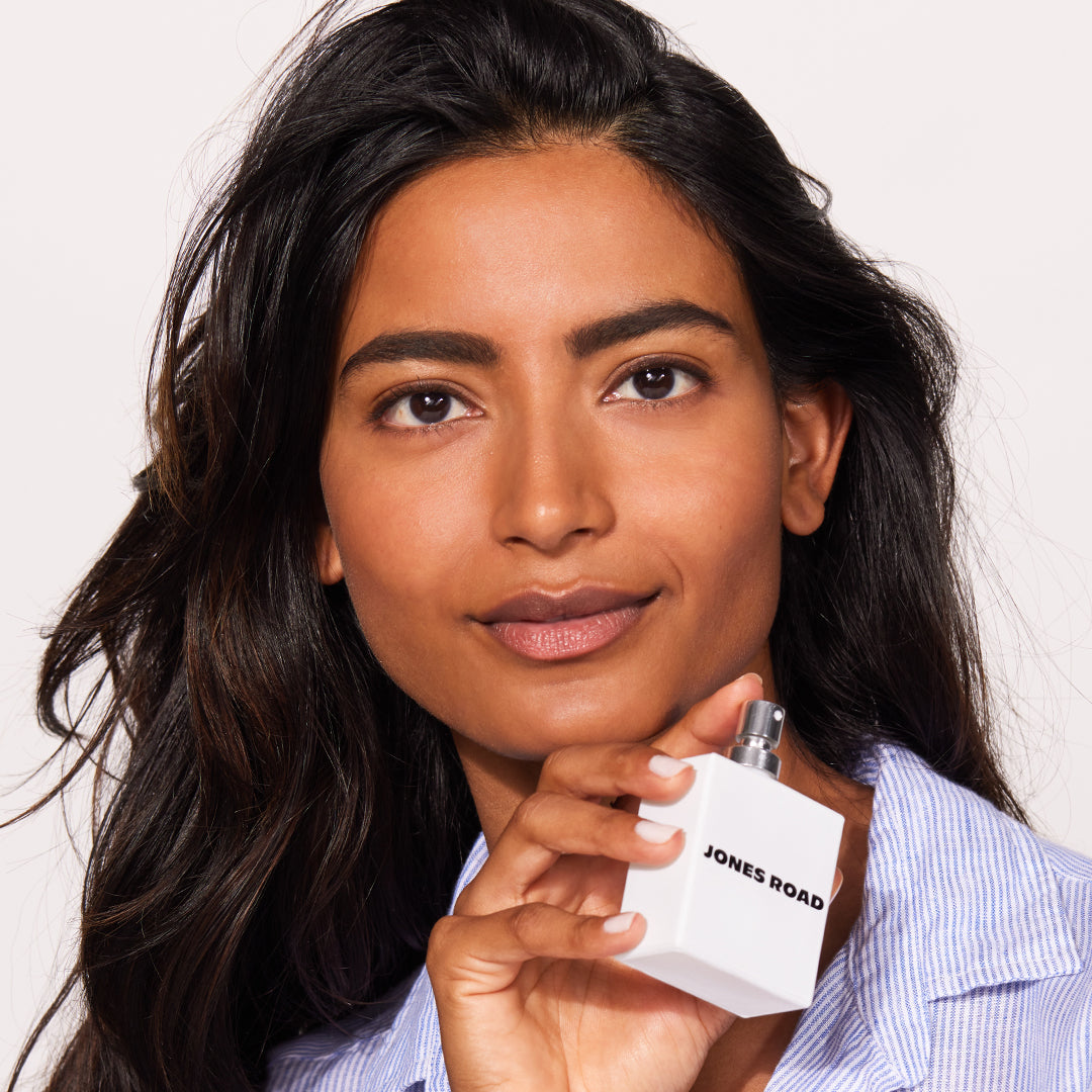 A woman showing Jones Road Beauty's new shower fragrance