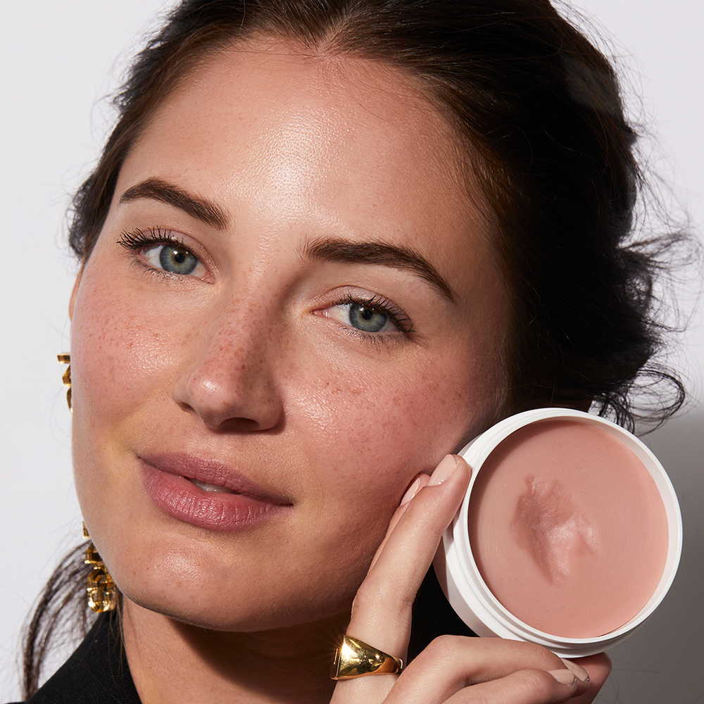 A woman holding Miracle Balm in Au Naturel by Jones Road Beauty