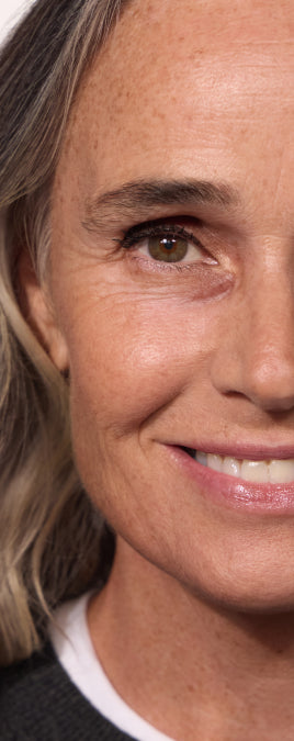 Model holding a pot of Wide Awake Brightening Concealer beside her face